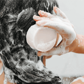 Applying solid shampoo bar for all hair types, ideal for dry and damaged hair, creating rich lather.
